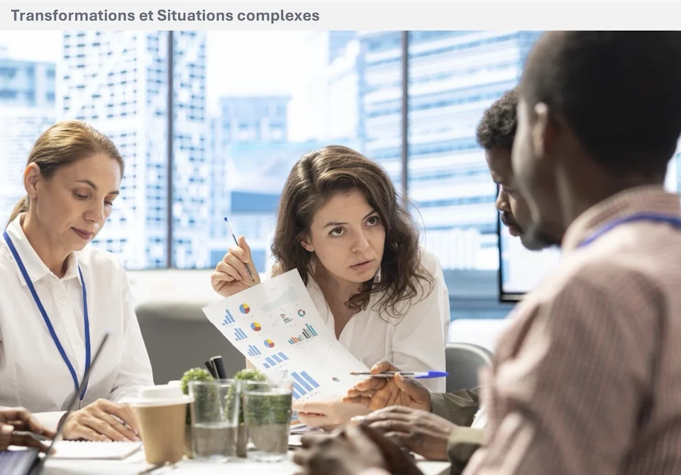 Plusieurs personnes échangent autour de documents et de graphiques lors d’une réunion de travail.