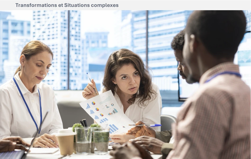 Plusieurs personnes échangent autour de documents et de graphiques lors d’une réunion de travail.